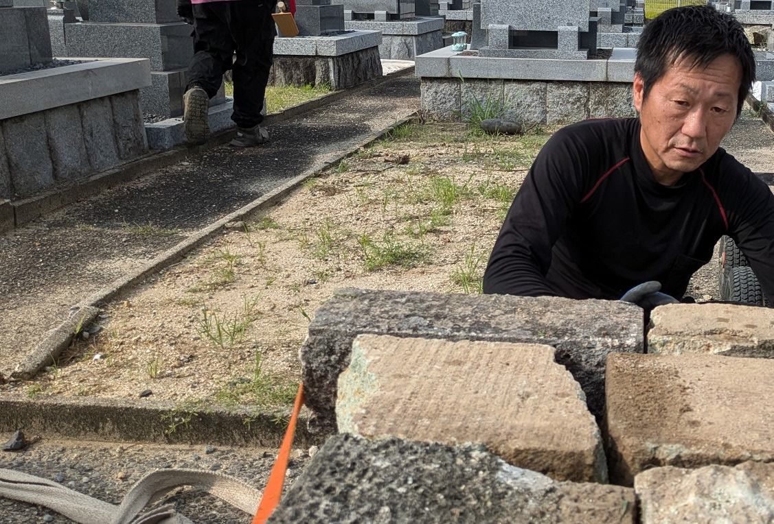 墓じまいの作業をしている筒木社長の写真