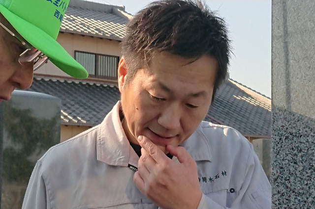 作業服姿の筒木社長が正面を向いて座っている写真